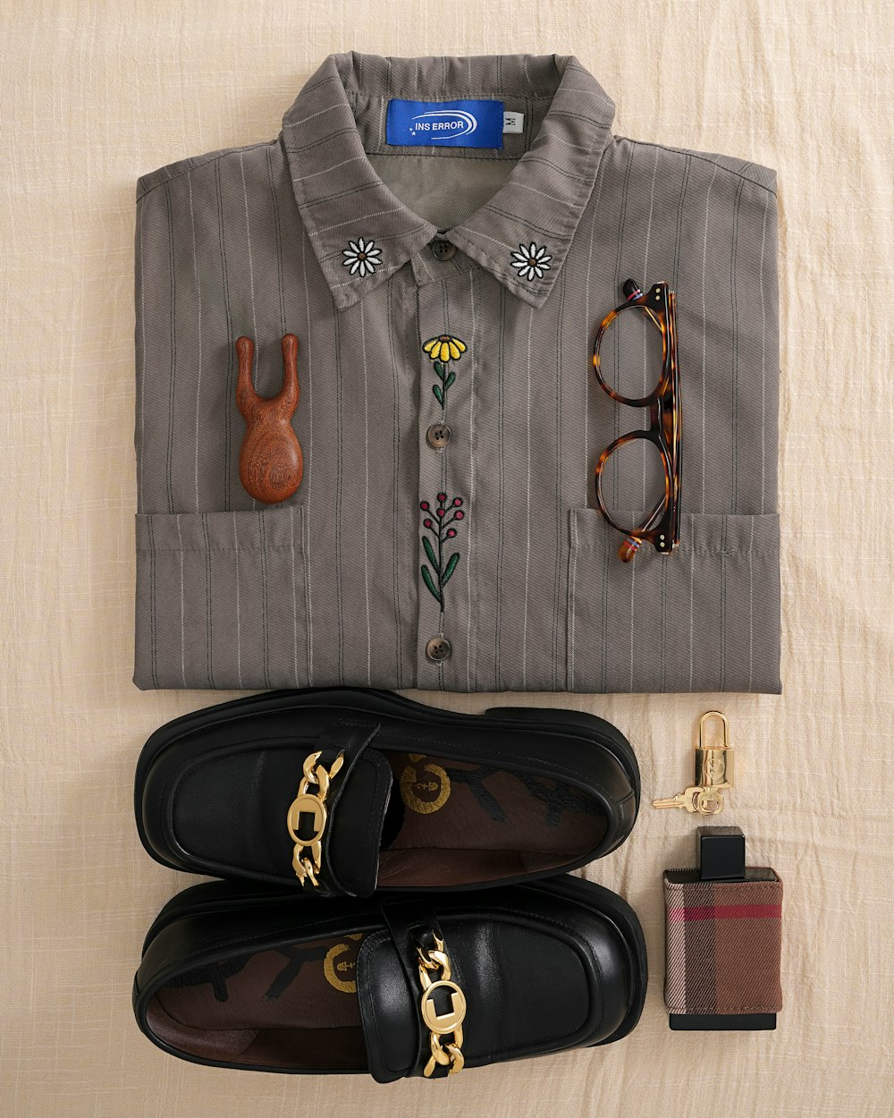 Chemise et accessoires présentés à plat pour montrer leurs détails